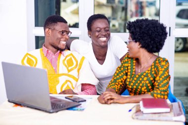 Mutlu yetişkin iş ortakları ofiste birlikte çalışırken gülümsüyor..