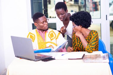 Yetişkin iş ortakları, raporları bir defterde birlikte kontrol ediyorlar, gülümsüyorlar..