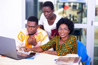 Ciddi yetişkin iş ortakları ofiste birlikte çalışırken gülümsüyor..