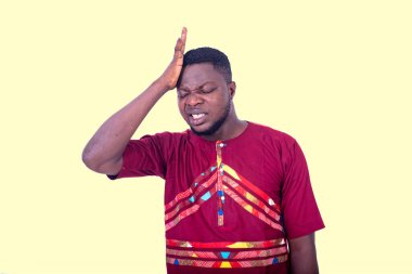 Başı ağrıyan kırmızı gömlekli yakışıklı bir genç..