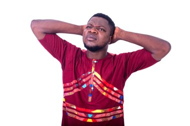 Kırmızı tişörtlü yakışıklı dalgın genç adam, ve ellerini kafasından tutuyor..