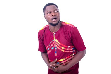 Yakışıklı genç adam karın ağrısı çekiyor ve ellerini karnının üstüne koyuyor..