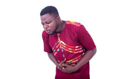 Yakışıklı genç adam karın ağrısı çekiyor ve ellerini karnının üstüne koyuyor..