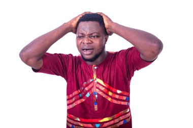 Yakışıklı, hayal kırıklığına uğramış genç bir adam, muhteşem bir gömlek giyiyor ve iki eliyle başını tutuyor..