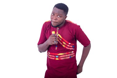 Beyaz arka planda duran peştemalli yakışıklı bir adam elinde küçük bir şişe alkol tutuyor.