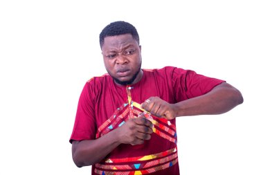 Beyaz arka planda duran peştemalli yakışıklı bir adam bir şişe içkiyi güçlükle açıyor..