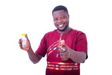 Beyaz arka planda duran peştemalli yakışıklı bir adam elinde bir şişe alkol ve gülümsüyor..