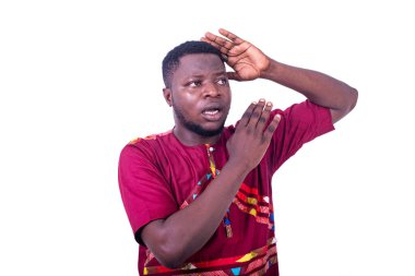 Geleneksel gömlekli yakışıklı, şaşırmış genç adam kolunu sallıyor..