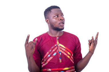 Geleneksel gömlek giyen yakışıklı, ciddi, genç bir adam parmaklarını işaret ediyor..