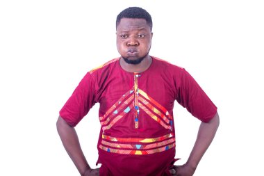 Yakışıklı genç adam ellerini kalçasında tutuyor ve yanaklarını ekşitiyor..