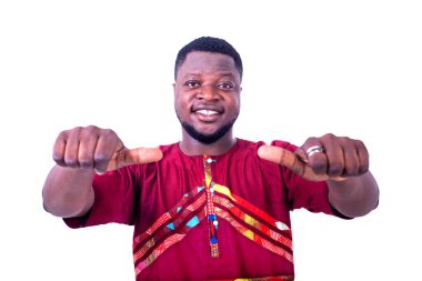 Kameraya gülümserken parmaklarını gösteren geleneksel tişörtlü yakışıklı bir genç..