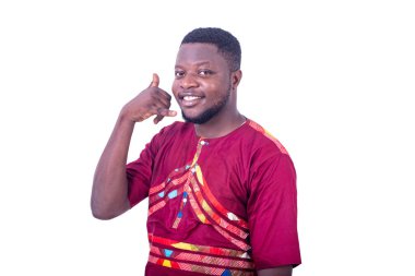 Beyaz arka planda duran peştemalli yakışıklı genç adam gülümserken telefon hareketi yapıyor..