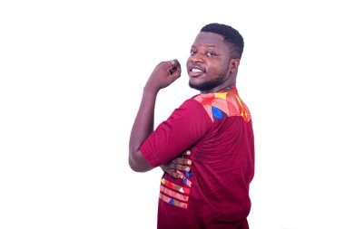 Peştemallı yakışıklı genç adam beyaz arka planda profilde duruyor kameraya bakıp gülümsüyor..