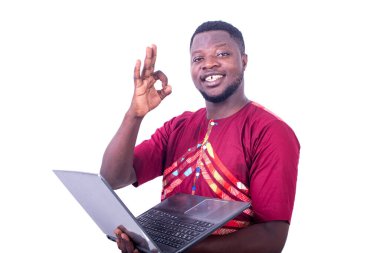 Yakışıklı, yetişkin bir adam elinde bilgisayarla kameraya gülümserken doğru bir hareket yapıyor..