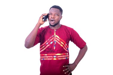 Şaşırmış genç bir adam cep telefonuyla konuşuyor..