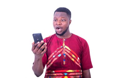 Cep telefonu kullanan ağzı açık, yakışıklı, şaşırmış yetişkin bir adam.