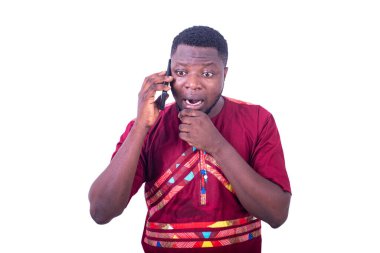 Eli ağızda cep telefonuyla konuşan genç, şaşkın bir adam..