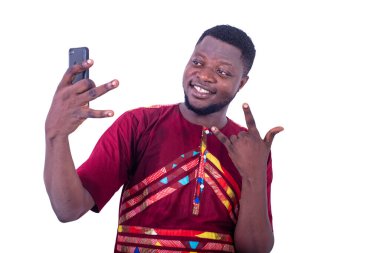 Yakışıklı, mutlu genç adam cep telefonuyla fotoğraf çekiyor. Parmakları gülümsüyor..