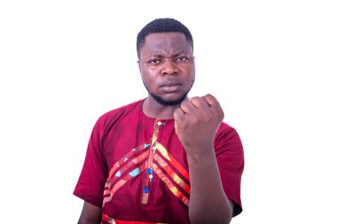 Yakışıklı, ciddi, genç bir adam kameraya yumruğunu gösteriyor..