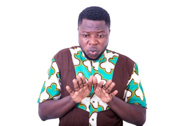 Peştemalli genç bir adam beyaz arka planda duruyor ve ellerini kullanarak reddediyor..