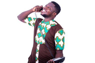 Genç adam ayakta duruyor ve beyaz bir arka planda güzel bir gülümsemeyle iletişim kuruyor..