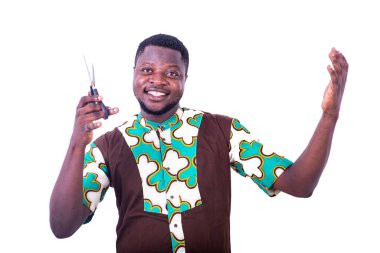 Yakışıklı, mutlu genç bir adam elinde bir makas tutuyor ve kameraya gülümsüyor..