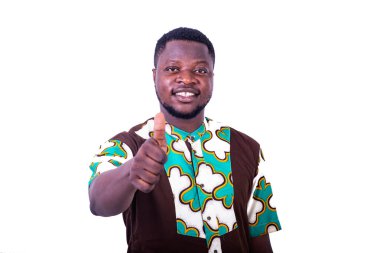 Beyaz arka planda duran yakışıklı genç bir adam parmağını kaldırıyor ve gülümseyen kameraya bakıyor..