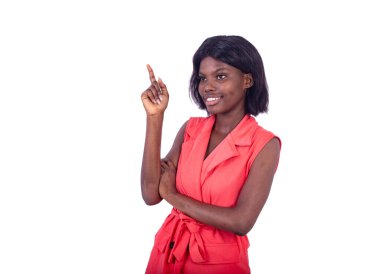 Beyaz arka planda duran ceketli genç bir kadın parmağını kaldırıp gülümsedi.