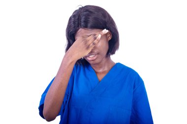 Beyaz arka planda duran üniformalı genç bayan hemşire steteskopla gözlerinde acı hissediyordu..