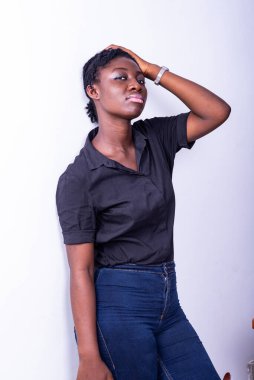 Genç bir öğrenci beyaz bir arka planda elleri başının üstünde mutsuz görünüyor.