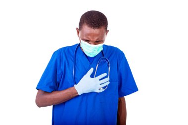 Üniformalı genç bir doktor steteskopla beyaz arka planda duruyor ve elleri göğsünde bir maske takıyor..