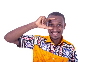 Beyaz arka planda duran kolsuz gömlekli yakışıklı genç bir işadamı gülme hareketi yapıyor.