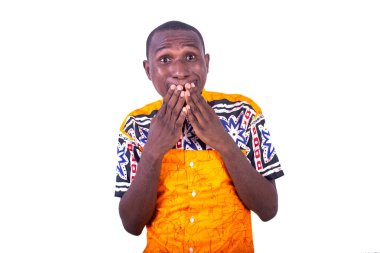 Beyaz arka planda duran gömlek giyen yakışıklı genç bir işadamı surat yapıyor.