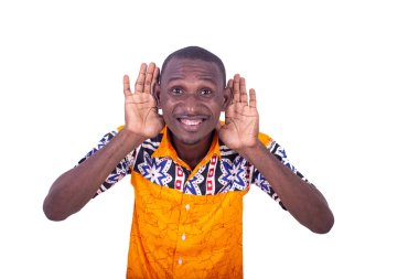 Beyaz arka planda duran, elleri kulaklarında, gülümseyen bir şeyi dinleyen yakışıklı, genç bir iş adamı.