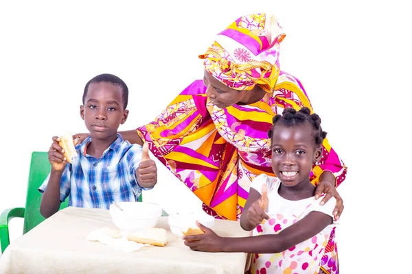 漂亮的成年母亲看着她的孙子孙女们在餐桌边吃早餐 孩子们一起露出大拇指 微笑着 — 图库照片