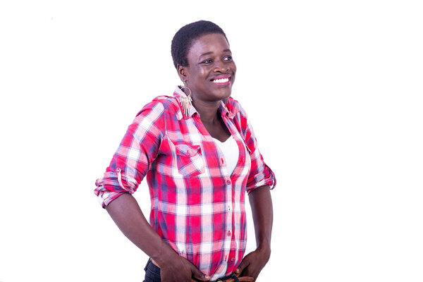 Young woman in checkered shirt standing on white background looking in profile smiling