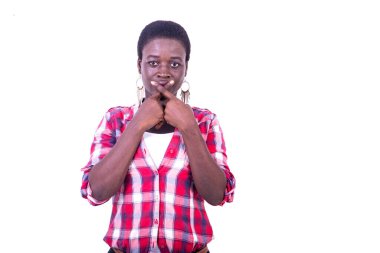 young beautiful woman in checkered shirt standing on white background crossing fingers over mouth and looking at camera