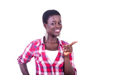 beautiful young woman pointing finger aside smiling at camera; isolated on white background.