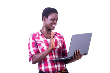 young woman having a video call on the laptop and waving her hand to greet her partner.