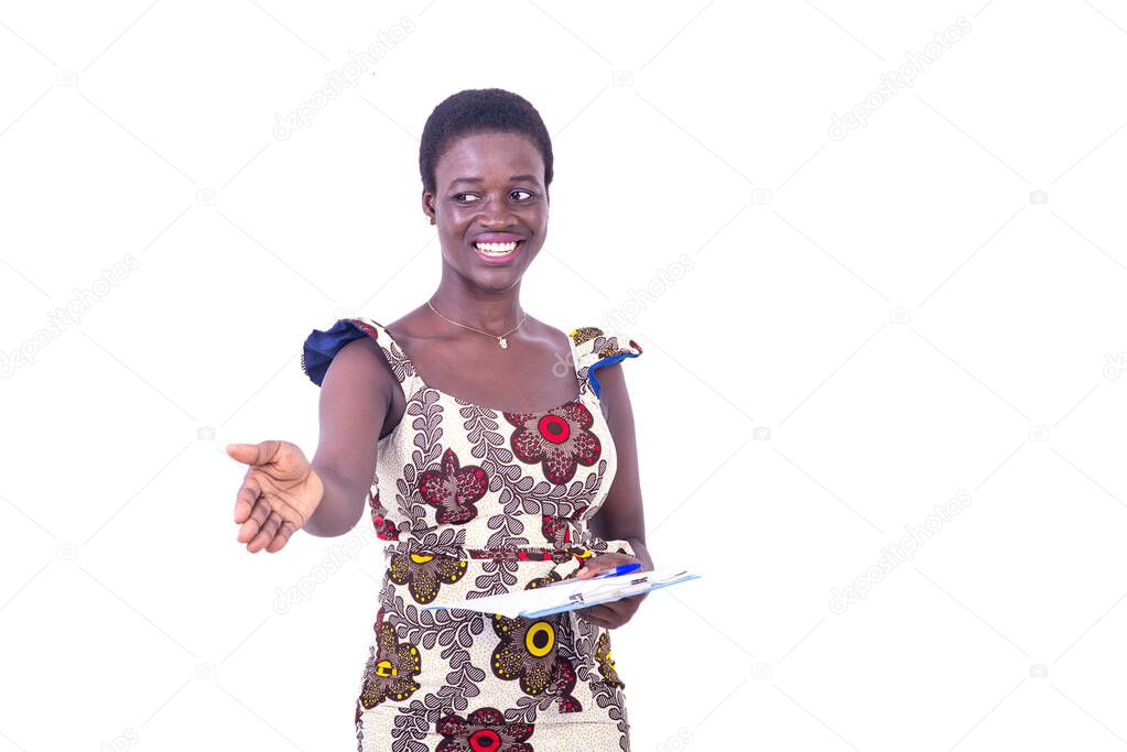 beautiful young businesswoman in dress standing on white background going to greet someone and holding document while smiling