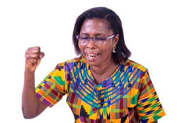 Gözlüklü yetişkin bir kadın. Gözleri kapalı duruyor. Yumruğunu kaldırıyor..