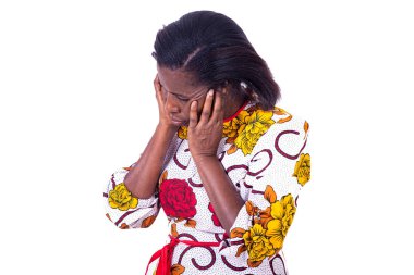 Beyaz bir arka planda duran, çiçekli olgun bir kadın kulak ağrısı çekiyor.