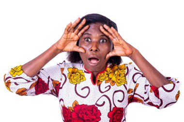 Beyaz bir arka planda duran, çiçek takan olgun bir kadın.