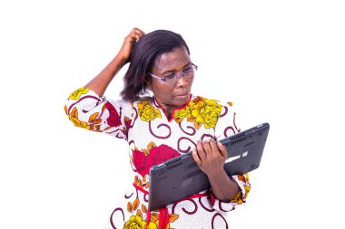 Gözlüklü bir kadın beyaz bir arka planda durup düşünüyor ve bir laptop taşıyor.