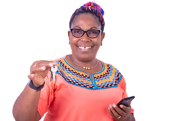 Dojrzała Kobieta Okularach Optycznych Trzymająca Telefon Komórkowy Kluczem Przy Uśmiechu — Zdjęcie stockowe