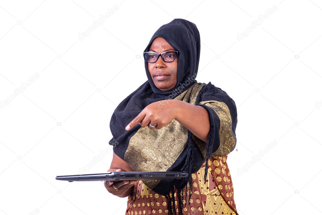 portrait of a mature muslim businesswoman, wearing glasses, pointing a finger at the laptop.