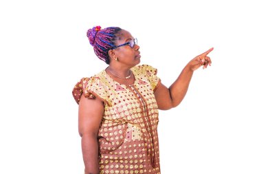 Olgun bir kadın gözlük takıyor, ayakta duruyor ve parmağıyla işaret ediyor..