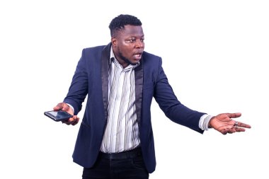 Genç, hayal kırıklığına uğramış iş adamı takım elbise giyiyor ve elinde bir cep telefonuyla yan tarafa bakıyor..