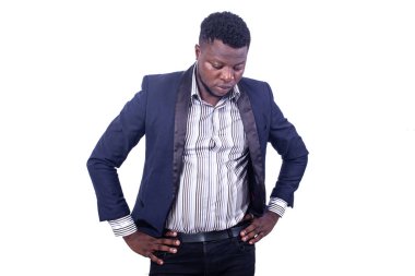 Düşünceli genç iş adamı zarif bir takım elbise giyiyor ve iki elini de kalçasında tutuyor..