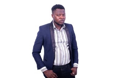 Genç ciddi iş adamı takım elbise giyiyor ve parmakları ceplerinde kameraya bakıyor..